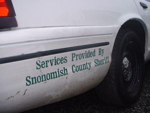 1999 Ford Crown Victoria - Side view of a white police car with "Services Provided By Snohomish County Sheriff" text visible on the rear quarter panel.