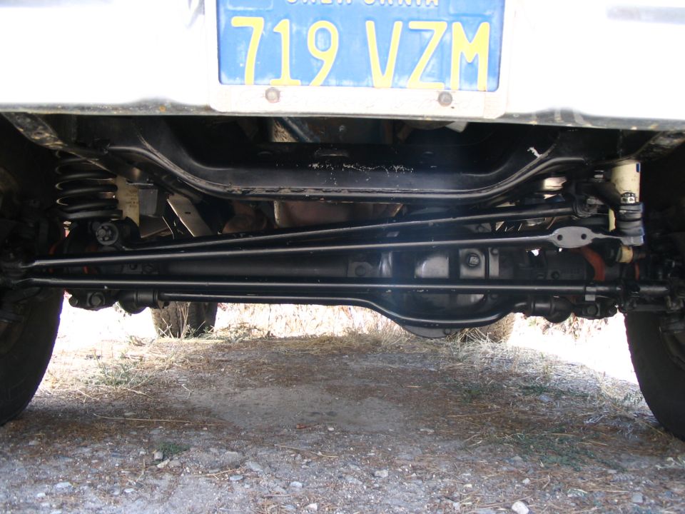 Underside front view of a Bronco showing solid axle, steering linkage, coil springs, and California plate 719 VZM