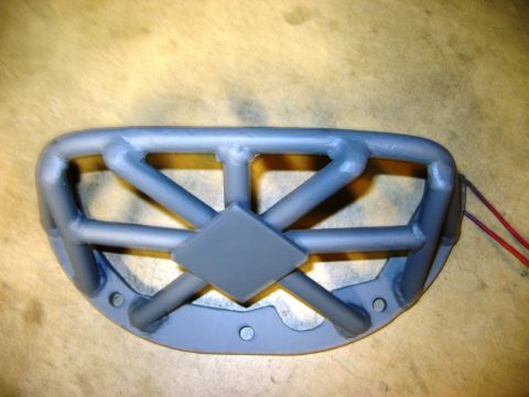 1985 Ford Bronco - A custom grille guard with a unique design and visible wiring is shown against a wooden background.