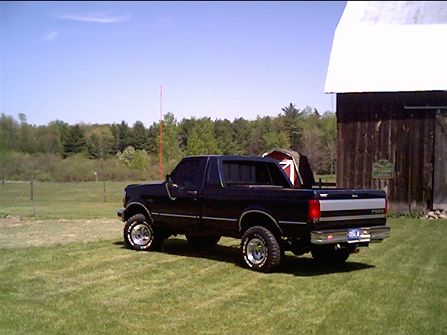 1995 Ford F-150 pickup truck parked on grass near a barn