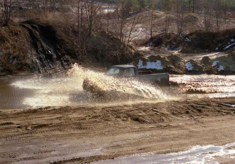 1991 Ford Bronco - A pickup truck navigates a muddy terrain, creating a large splash.