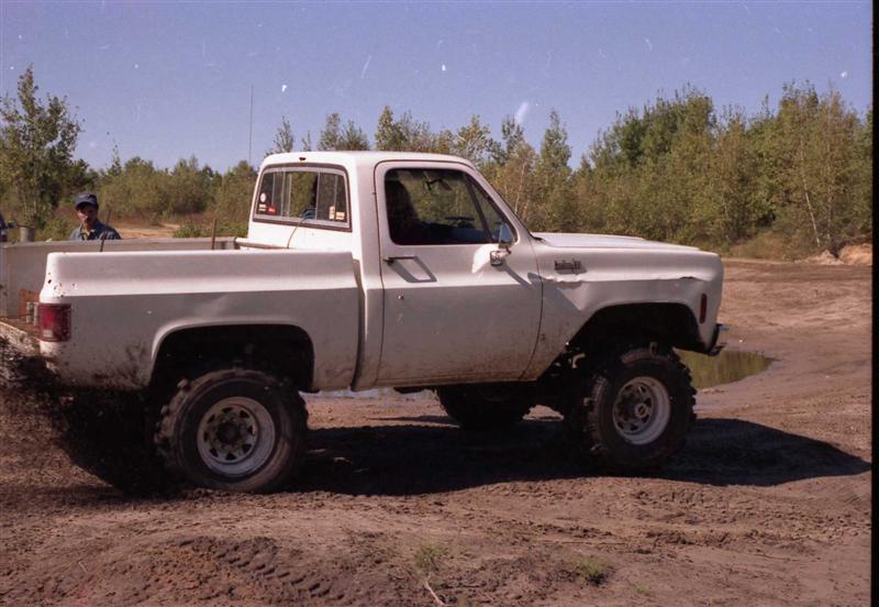 White pickup truck with off-road tires, side view. 1973 model