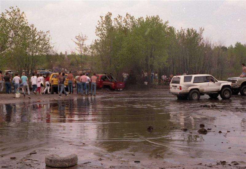 White 1989 Toyota 4Runner driving through mud pit