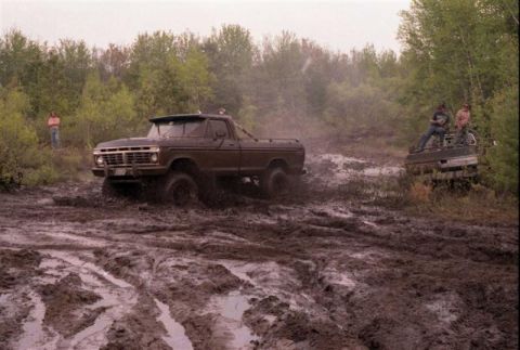 1991 Ford Bronco - A 1977 Ford F-Series truck is stuck in the mud, with another vehicle visible in the background.