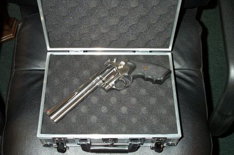 1998 Ford Crown Victoria - Revolver in a case on a leather chair.