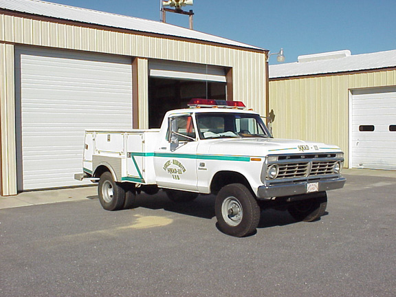 1973 Ford F-250 utility truck with "SQUAD 111" markings and emergency lights on roof