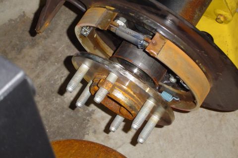 1993 Ford Bronco - Close-up of a rusted brake drum assembly, showing wheel studs and brake shoes.