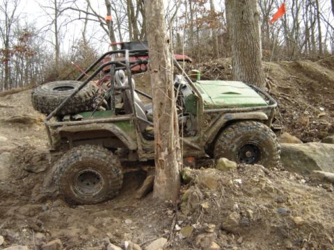 1992 Ford Bronco - Modified Jeep Wrangler navigating difficult off-road terrain with another vehicle visible behind it.