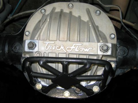 1985 Ford Bronco - Close-up of a vehicle's rear differential cover a Trick Flow brand plate and a custom protective cage.