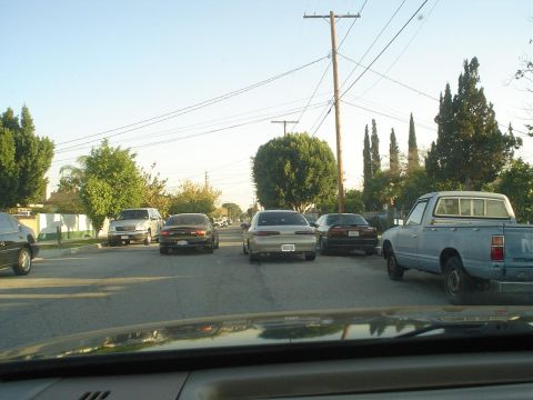1993 Ford Taurus - A street scene with multiple vehicles, including a pickup truck, parked along the road.