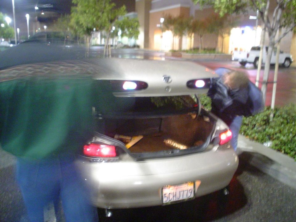 Gold sedan's open trunk with items inside. California license plate 5CHJ779 is visible