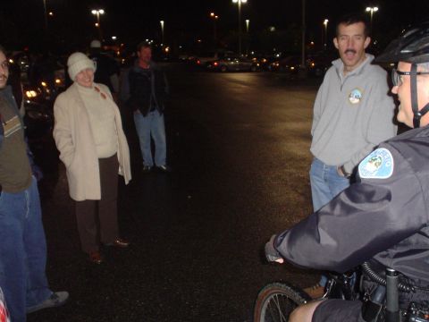 1993 Ford Taurus - Several individuals stand in a parking lot after dark, illuminated by overhead lights.