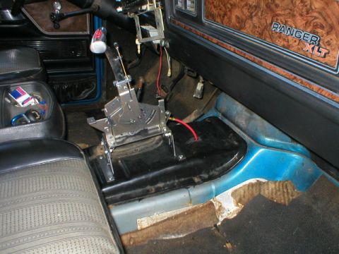 1978 Ford Bronco - Interior floor view of a Ford truck showing a chrome floor-mounted automatic shifter with a white shift knob, exposed transmission tunnel,…