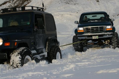1996 Ford Bronco - A green Ford F-Series truck, likely a 1995 model, is being towed by a Jeep in a snowy landscape.