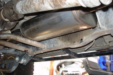 1987 Ford Bronco - Underside view of a vehicle's exhaust system, showing the muffler and drive shaft components.