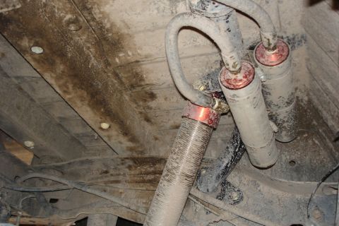 1987 Ford Bronco - Close-up view of the dusty rear shock absorbers and suspension components of a vehicle.