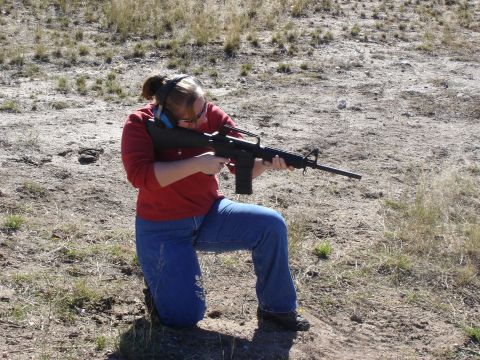 1987 Ford Bronco - Woman practices shooting with a rifle at an outdoor range.
