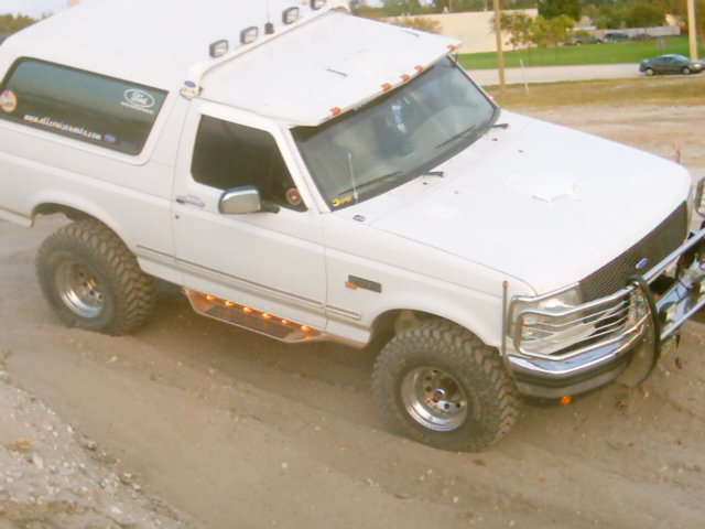 White 1995 Ford Bronco with off-road tires and custom lighting
