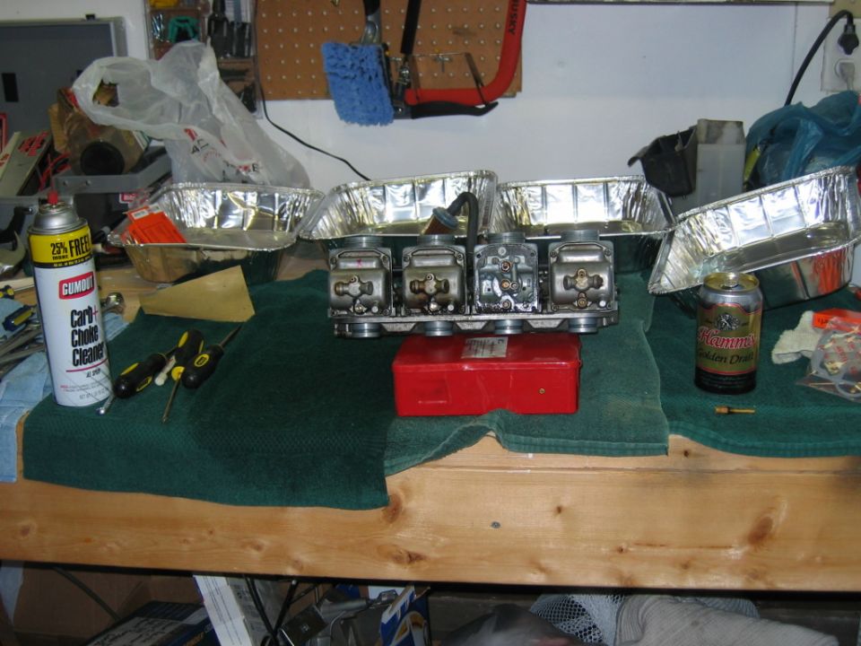 Carburetor assembly on workbench with carb cleaner and tools