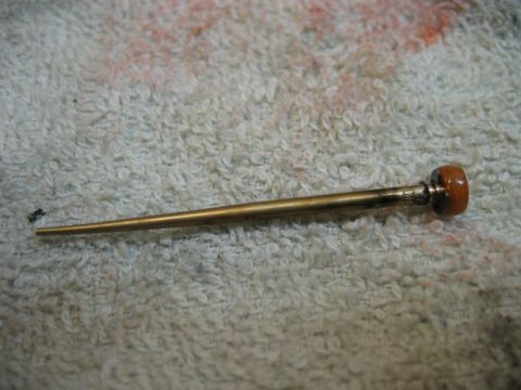 1985 Ford LTD Crown Victoria - A close-up view of a carburetor needle valve, likely for a vintage vehicle, resting on a textured cloth.