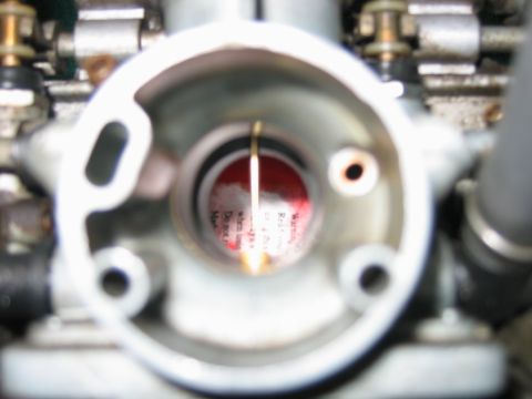 1985 Ford LTD Crown Victoria - Close-up view inside a carburetor, revealing a red warning label with text.