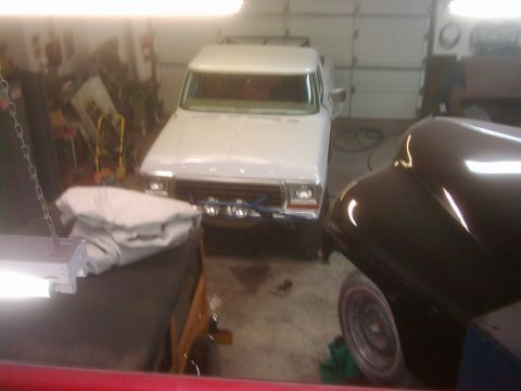 1978 Ford Bronco - A white 1978 Ford Bronco is parked in a garage, partially obscured by another vehicle.