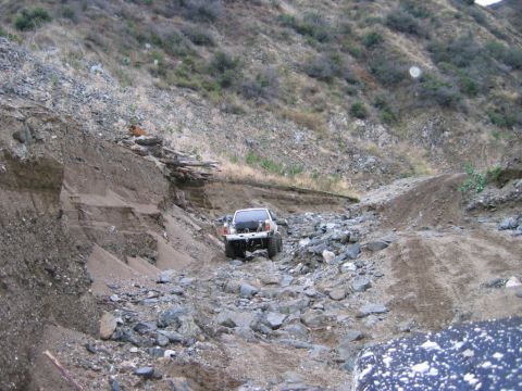 1985 Ford Bronco - A vehicle navigates a difficult, debris-strewn path through a hillside.