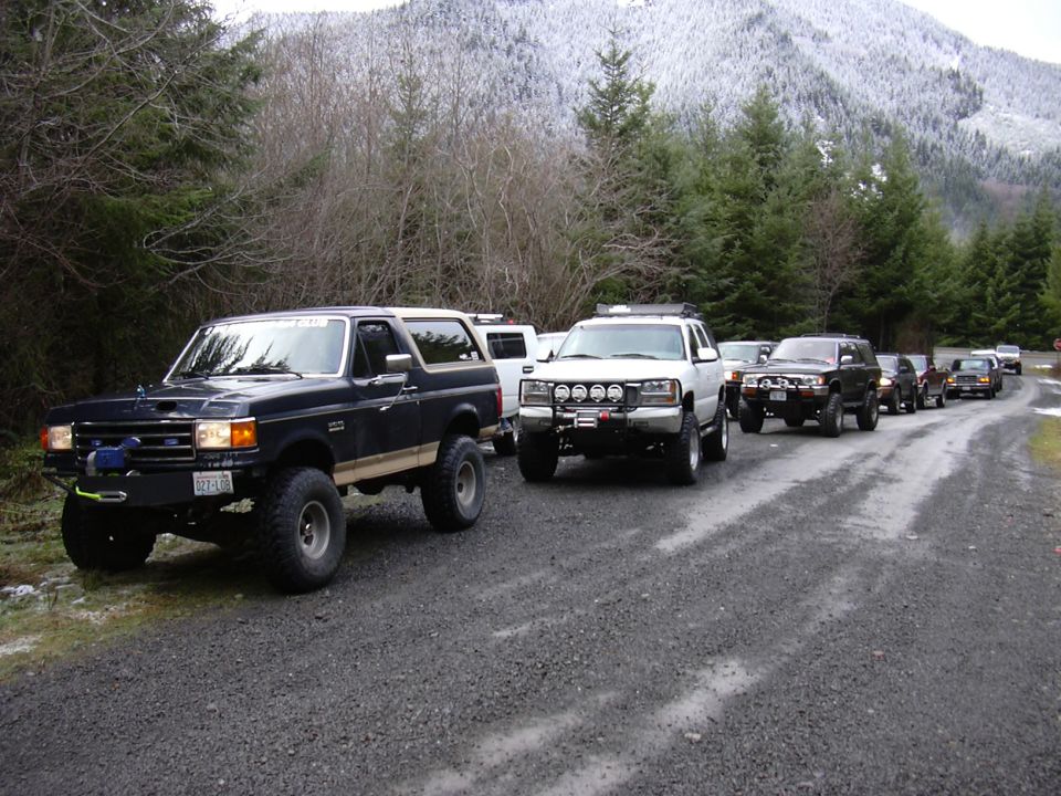 Black 1991 Ford Bronco with winch, lifted suspension, in a line of SUVs