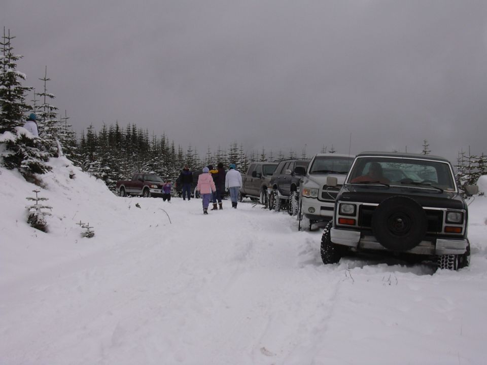 Black Ford Bronco with spare tire on the front, parked in snow