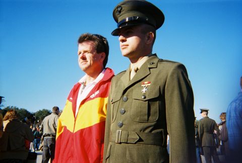 1994 Ford Bronco - A Marine in dress uniform stands beside a civilian man in a brightly colored jacket, with other people in the background.