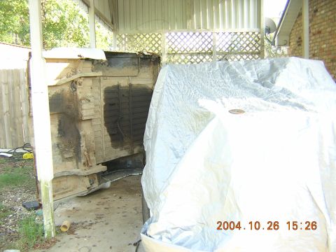 1984 Chevrolet Blazer - A vehicle body is exposed while another vehicle is covered by a tarp, with a timestamp of 2004.10.26 visible.