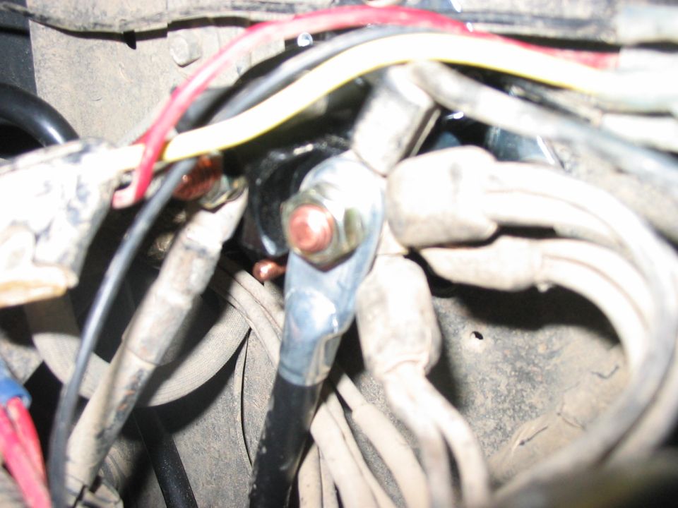 Close-up of starter motor wiring with copper terminals and red and yellow wires