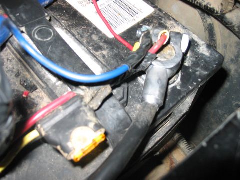 1988 Ford Bronco - Close-up of car battery terminals and wiring, showing connections and a fuse.