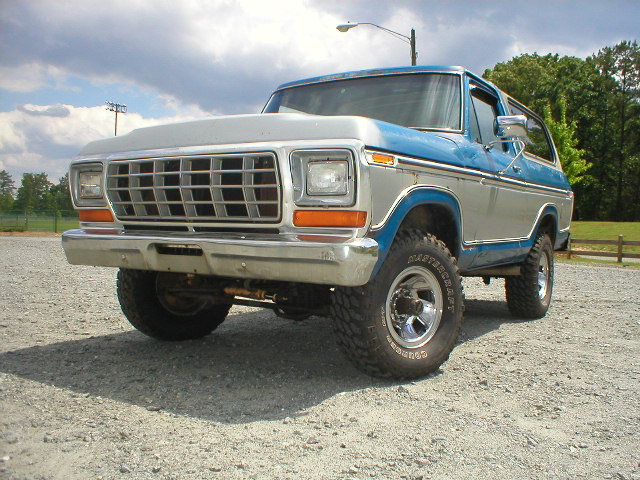 1978 Ford Bronco with blue and silver paint, parked on gravel