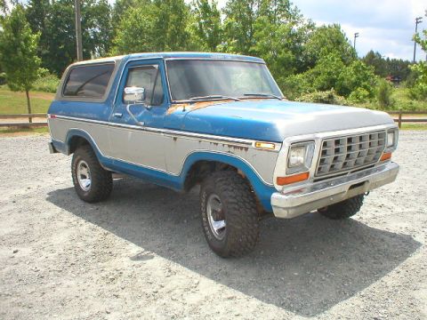 1978 Ford Bronco - This classic Ford Bronco sits on a gravel lot, showing off its two-tone paint and off-road tires.