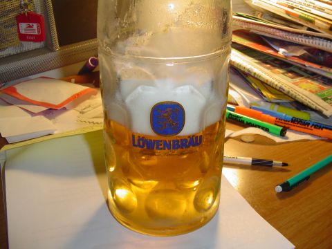 1990 Ford Bronco - A mug of Lowenbrau beer sits on a desk next to papers and writing utensils.