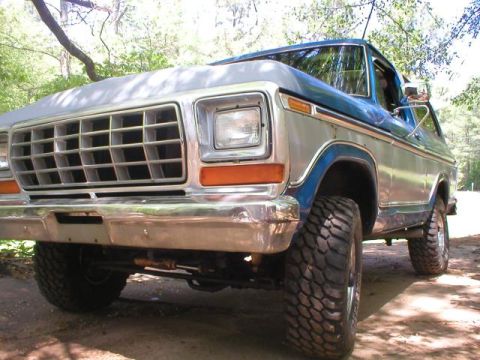 1978 Ford Bronco - The front end of a classic Ford Bronco is shown, a prominent grille and large off-road tires.