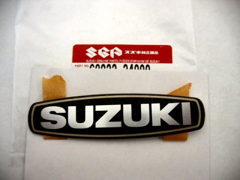 1985 Ford LTD Crown Victoria - A Suzuki emblem is shown with packaging that includes part number details.