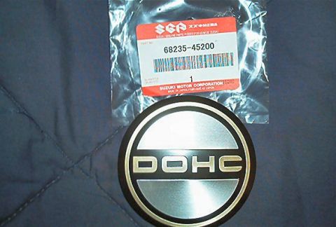 1985 Ford LTD Crown Victoria - A circular emblem reads DOHC, with a Suzuki part number visible on the packaging.
