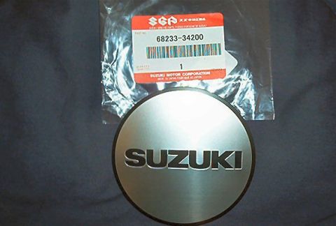 1985 Ford LTD Crown Victoria - A Suzuki emblem is shown with its original packaging, which includes the part number 68233-34200.