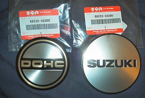1985 Ford LTD Crown Victoria - Two new Suzuki DOHC hubcaps are shown with their original packaging and part numbers.
