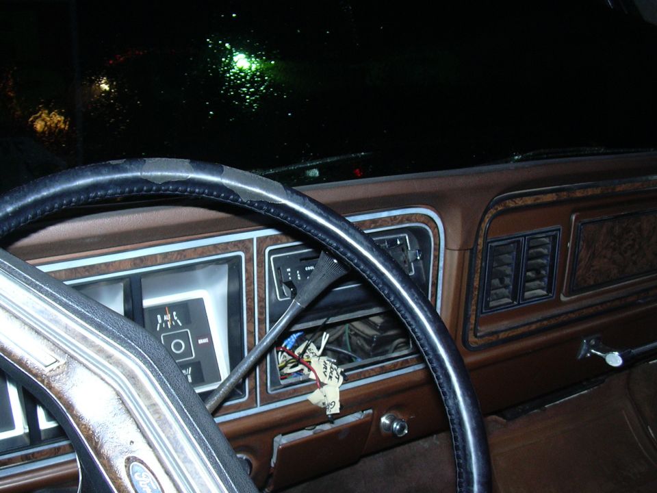 1978 Ford Bronco interior dashboard with wood grain trim and cracked steering wheel