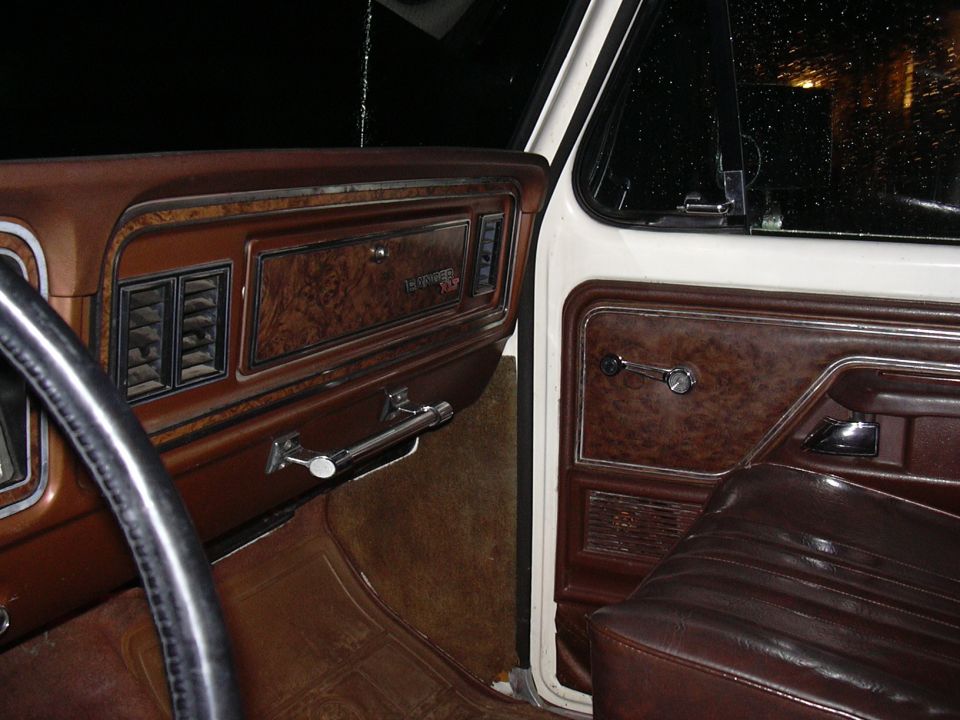 1978 Ford Bronco interior showing woodgrain dash trim, air vents, door panel, and seat