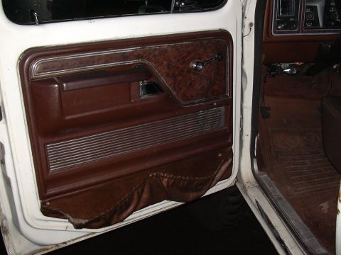 1978 Ford Bronco - The interior door panel shows signs of wear and tear, with damaged upholstery at the bottom.