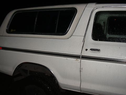 1978 Ford Bronco - Side view of a white 1978 Ford Bronco showing its body lines and trim.