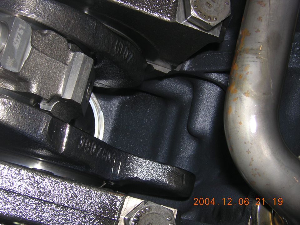Close-up of engine block casting with part number 3907881 and exhaust pipe