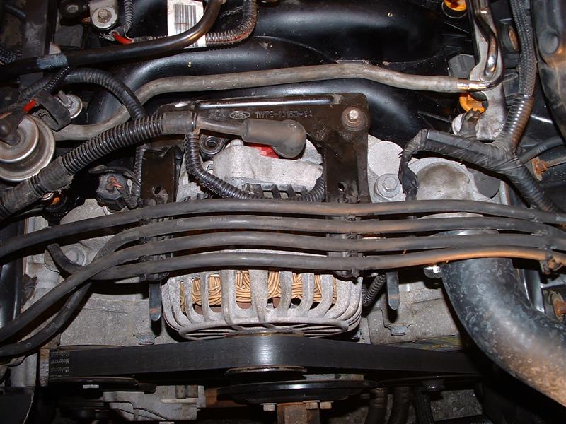 Engine bay with alternator, belts, and wiring visible