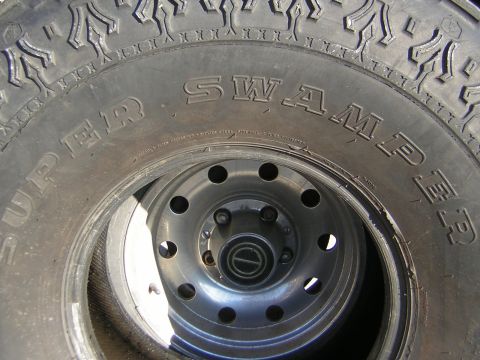 1995 Ford Bronco - A close-up view of a Super Swamper tire mounted on a silver wheel.