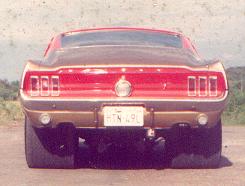 1967 Ford Mustang - The rear of a classic Ford Mustang, its distinctive taillights and dual exhaust pipes.