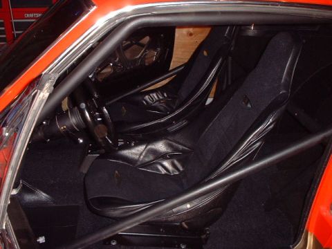 1967 Ford Mustang - The interior of the car features black racing seats and a roll cage, suggesting a performance-oriented build.